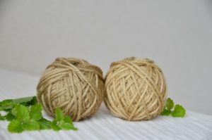 レモンバーベナ染めの毛糸が2玉レモンバーベナの葉と一緒においてある